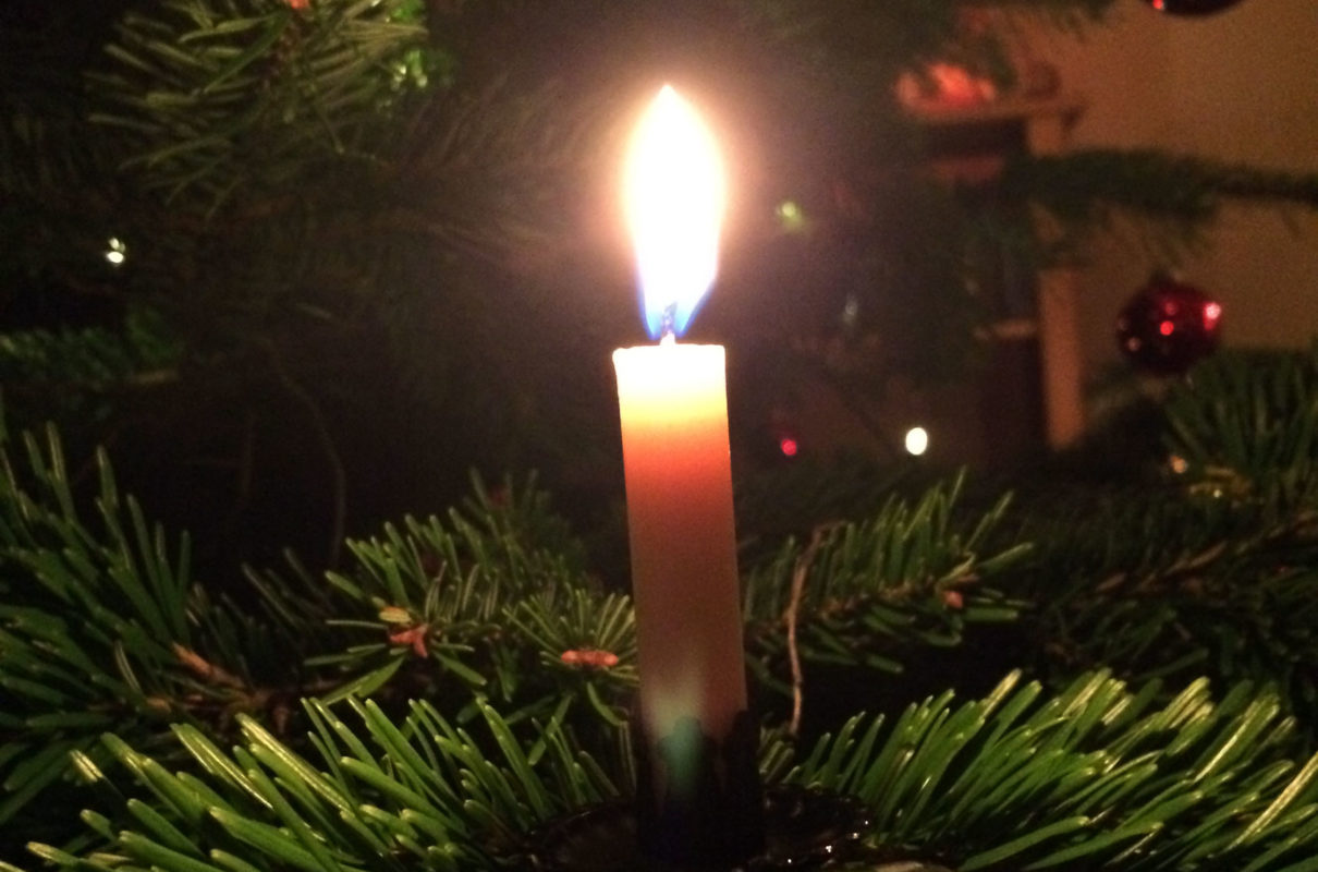 Brennende Kerze an einem Weihnachtsbaum